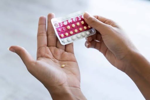 Close-up of young woman's hand holding pills